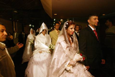 Newly married Iraqi couples arrive at a hotel for a mass wedding reception